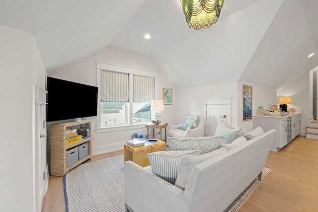 living room featuring lofted ceiling and light hardwood / wood-style floors