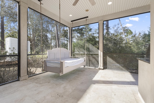 unfurnished sunroom featuring ceiling fan and plenty of natural light