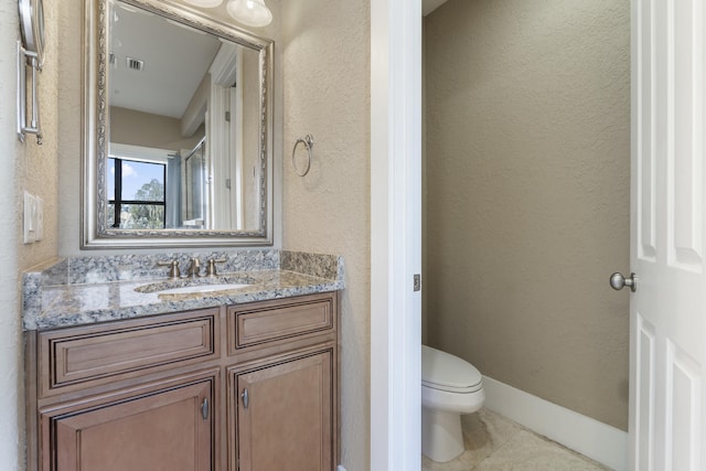 bathroom featuring toilet, tile patterned floors, and vanity