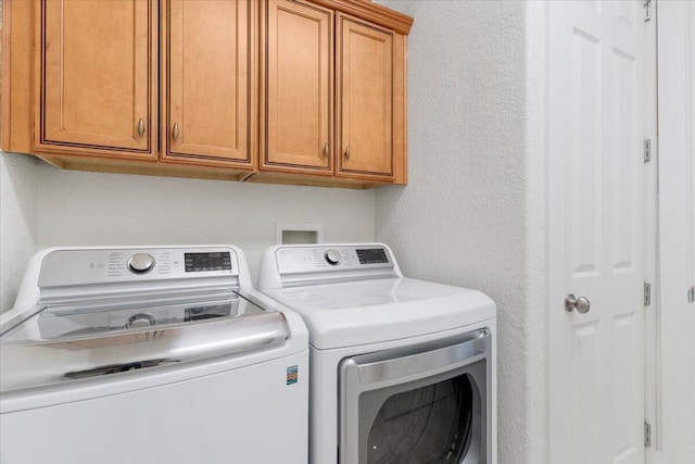 31 Beacon Point Dr, Santa Rosa Beach, FL 32459 - laundry area featuring washer and dryer, cabinet space, and a textured wall