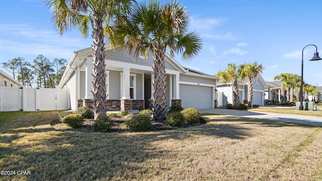 view of front facade with a front yard, a garage, and a porch