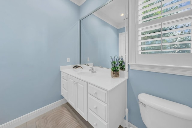 bathroom featuring vanity, ornamental molding, and toilet