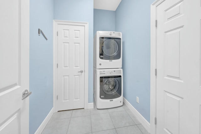 laundry room with stacked washer and dryer and light tile patterned floors