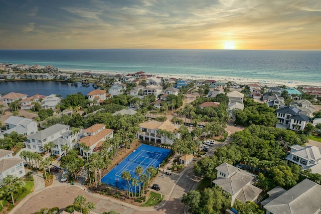 aerial view at dusk featuring a water view