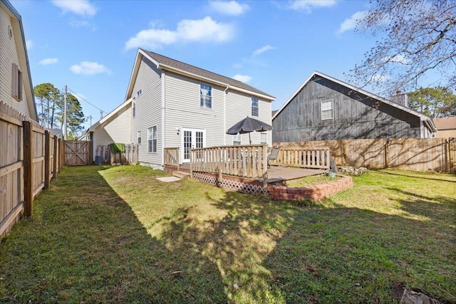 rear view of property featuring a deck and a yard