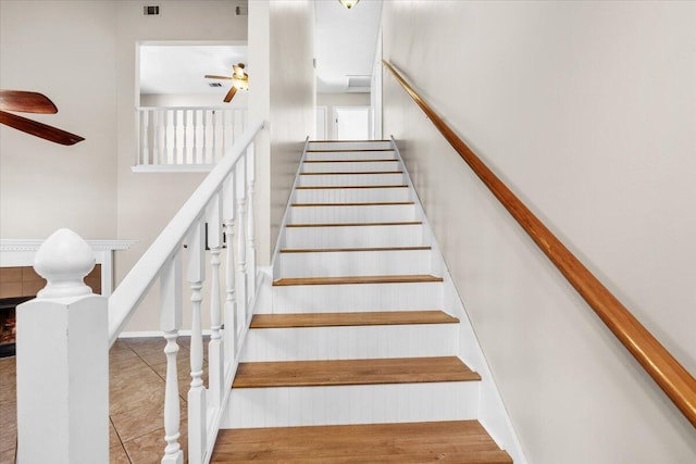 stairs featuring ceiling fan and tile patterned flooring