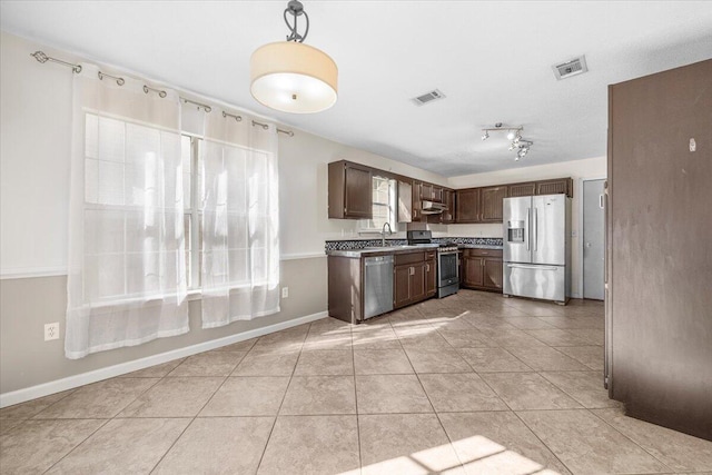 kitchen with light tile patterned floors, sink, dark brown cabinetry, and appliances with stainless steel finishes