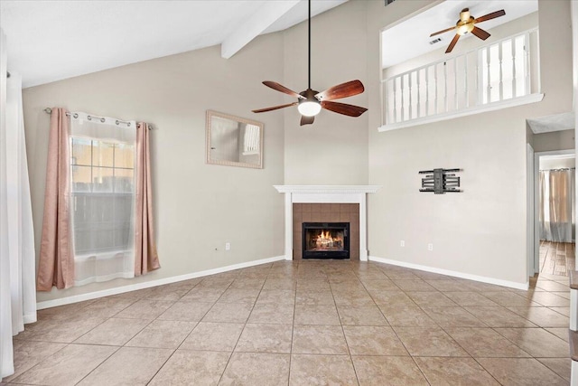 unfurnished living room featuring ceiling fan, light tile patterned floors, beamed ceiling, and a fireplace