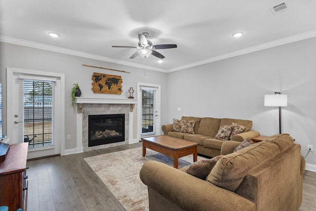 living room with hardwood / wood-style floors, crown molding, and ceiling fan