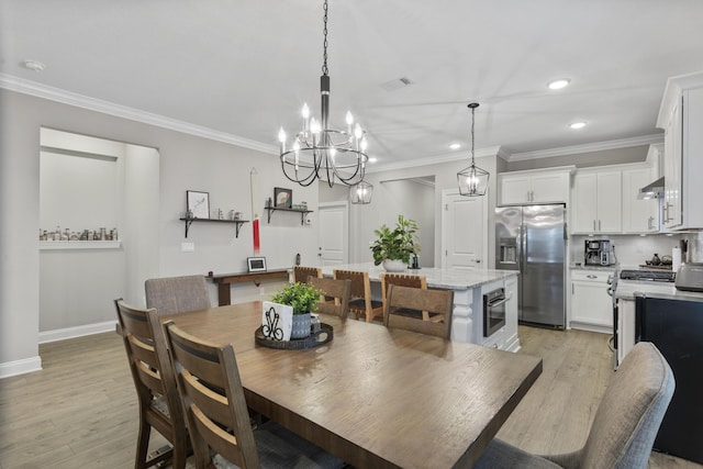 dining room with crown molding, a chandelier, and light wood-type flooring