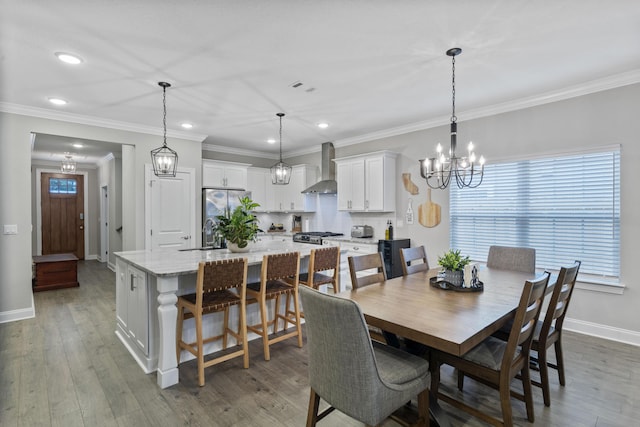 dining room with ornamental molding, dark hardwood / wood-style floors, sink, and an inviting chandelier