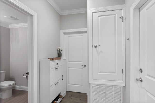 bathroom with hardwood / wood-style floors, ornamental molding, and toilet