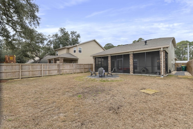 rear view of house with a sunroom and a lawn