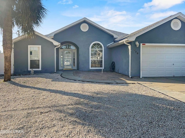 single story home featuring stucco siding, concrete driveway, and an attached garage