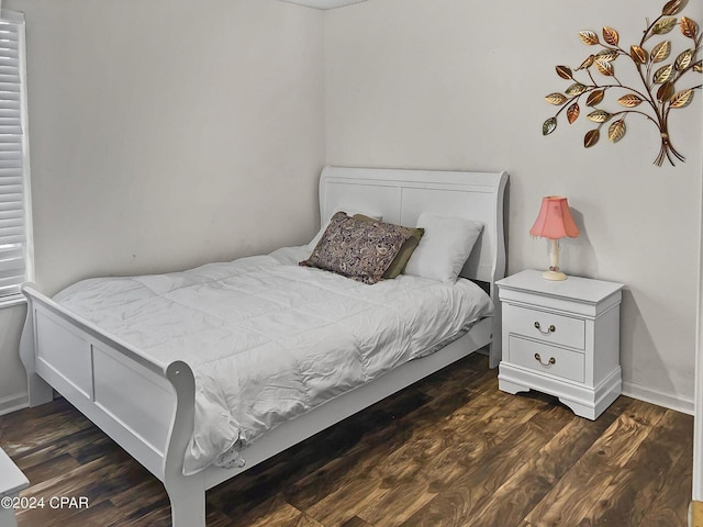 bedroom with wood finished floors and baseboards