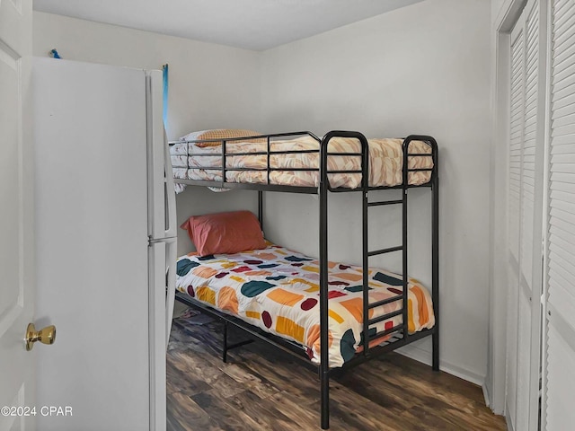 bedroom featuring freestanding refrigerator and wood finished floors