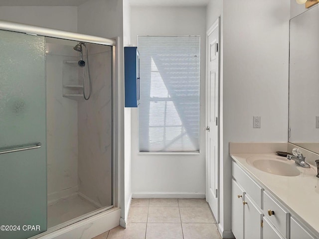 bathroom featuring baseboards, vanity, a shower stall, and tile patterned flooring