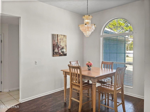 dining space with a notable chandelier, baseboards, and wood finished floors