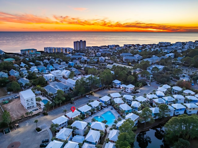 aerial view at dusk featuring a water view