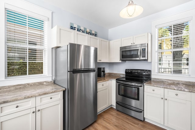 kitchen featuring white cabinetry, stainless steel appliances, and hardwood / wood-style floors