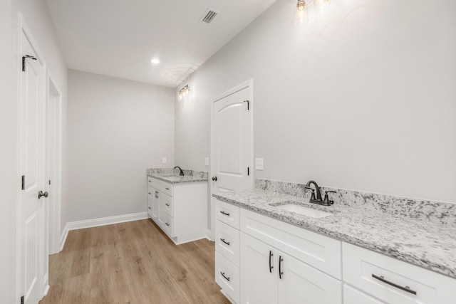 5848 Phillip Rd, Crestview, FL 32539 - bathroom featuring two vanities, wood finished floors, baseboards, and recessed lighting