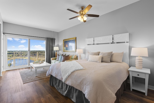 bedroom featuring dark wood-type flooring, ceiling fan, access to exterior, and a water view