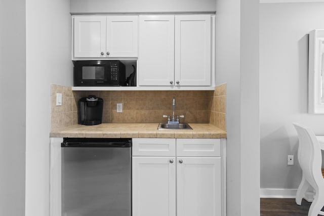 kitchen with tasteful backsplash, dishwashing machine, sink, and white cabinetry