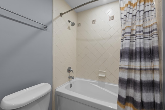 bathroom with toilet and tiled shower / bath