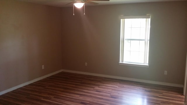 empty room featuring ceiling fan, plenty of natural light, and dark hardwood / wood-style floors