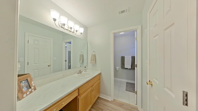 bathroom featuring vanity, hardwood / wood-style flooring, and a textured ceiling