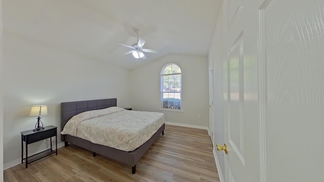 bedroom with ceiling fan, light hardwood / wood-style flooring, and lofted ceiling