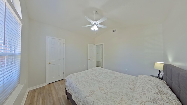 bedroom with ceiling fan, light hardwood / wood-style flooring, and vaulted ceiling