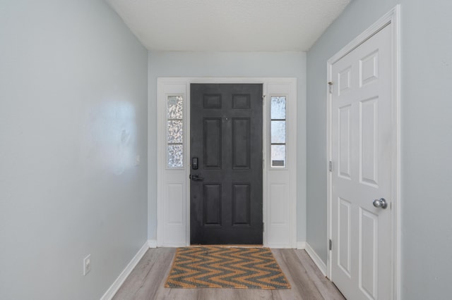 entrance foyer featuring a textured ceiling and light wood-type flooring