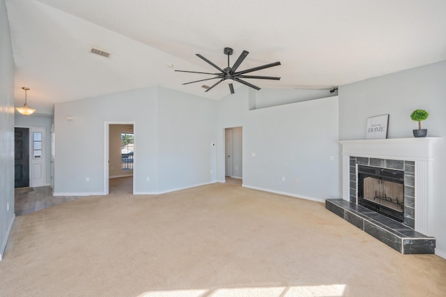 carpeted living room featuring ceiling fan, vaulted ceiling, and a tile fireplace