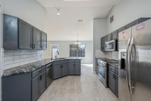 kitchen featuring decorative light fixtures, backsplash, appliances with stainless steel finishes, and sink