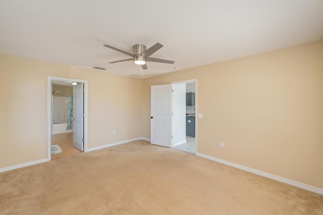 unfurnished bedroom featuring ceiling fan, ensuite bathroom, and light carpet