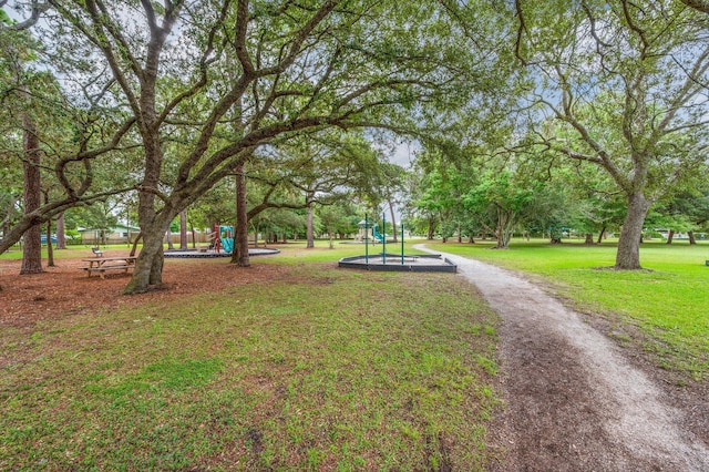 view of property's community featuring a lawn and a playground