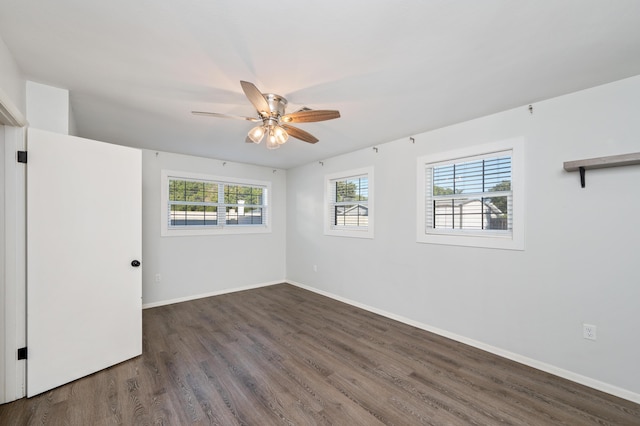 empty room featuring ceiling fan, a healthy amount of sunlight, and dark hardwood / wood-style floors