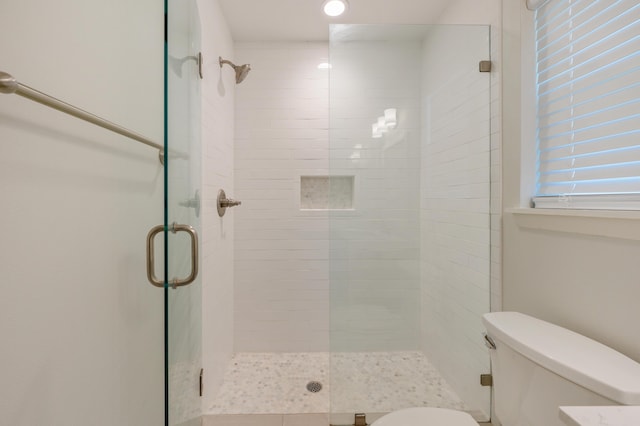 bathroom featuring an enclosed shower and toilet