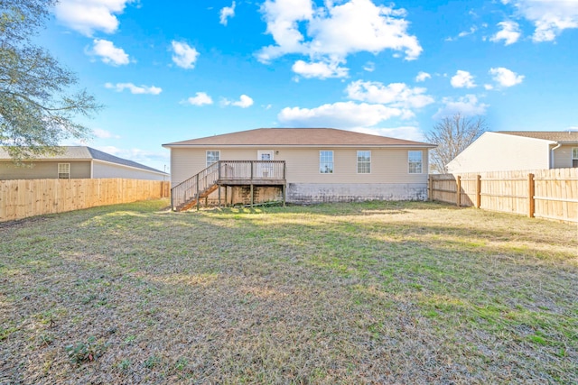 back of property with a wooden deck and a yard