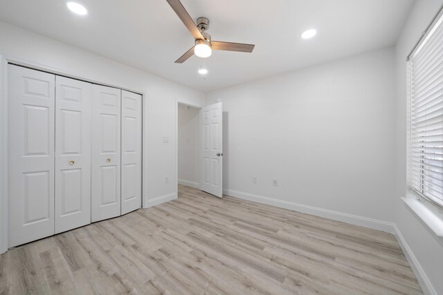 unfurnished bedroom with ceiling fan, multiple windows, a closet, and light wood-type flooring