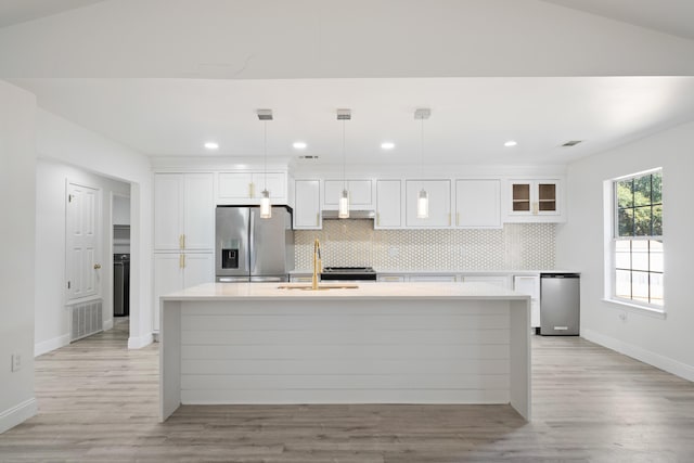 kitchen with pendant lighting, white cabinetry, appliances with stainless steel finishes, and tasteful backsplash