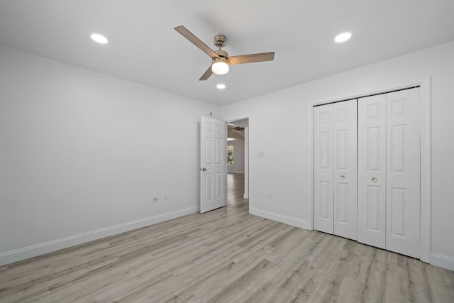 unfurnished bedroom with ceiling fan, a closet, and light wood-type flooring