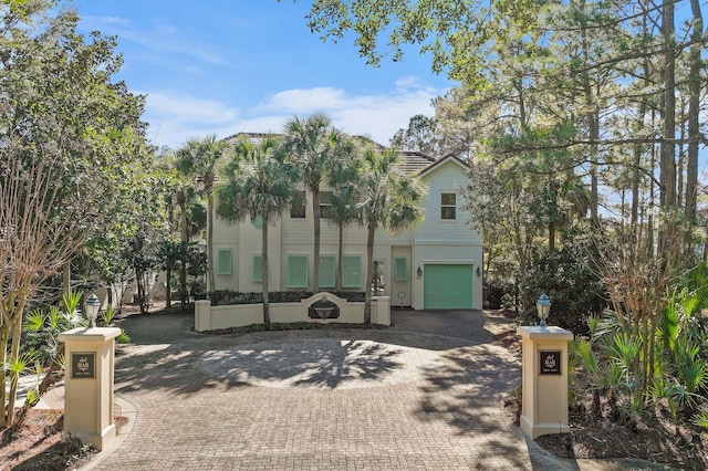 view of front of home with a garage and decorative driveway