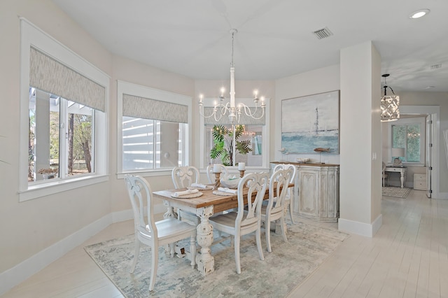 dining space featuring baseboards, plenty of natural light, visible vents, and a notable chandelier