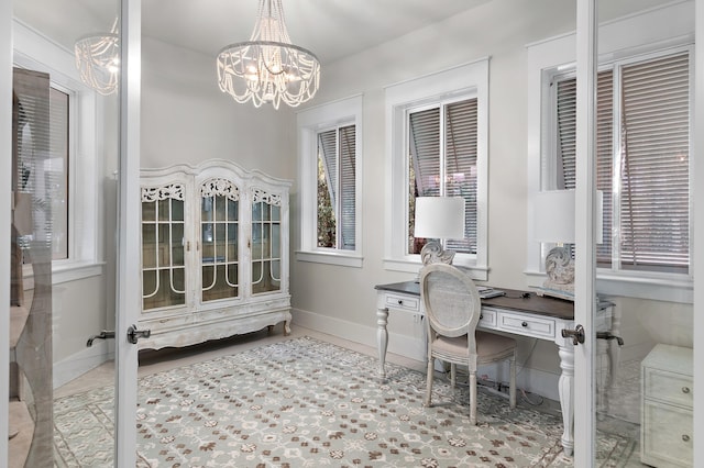 office space featuring an inviting chandelier, baseboards, and tile patterned floors