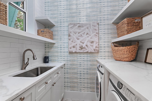 kitchen featuring light stone counters, open shelves, tasteful backsplash, a sink, and independent washer and dryer