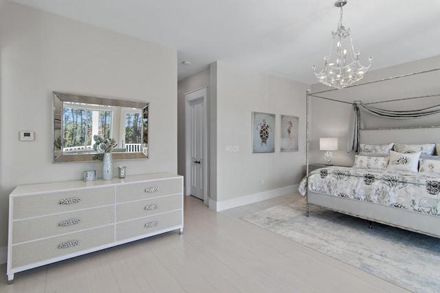 bedroom featuring baseboards, a chandelier, and wood finished floors