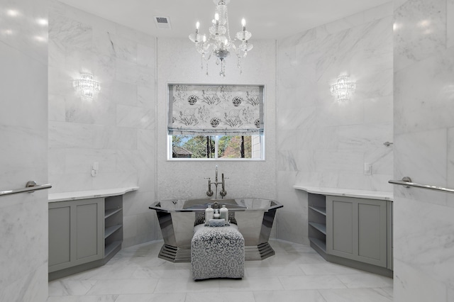 bathroom featuring visible vents, a freestanding bath, tile walls, and a notable chandelier