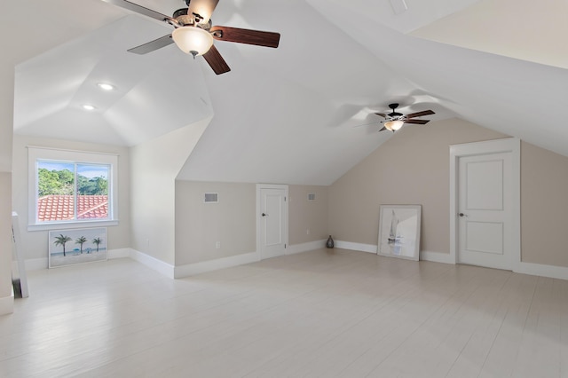 additional living space featuring lofted ceiling, light wood-style floors, baseboards, and visible vents